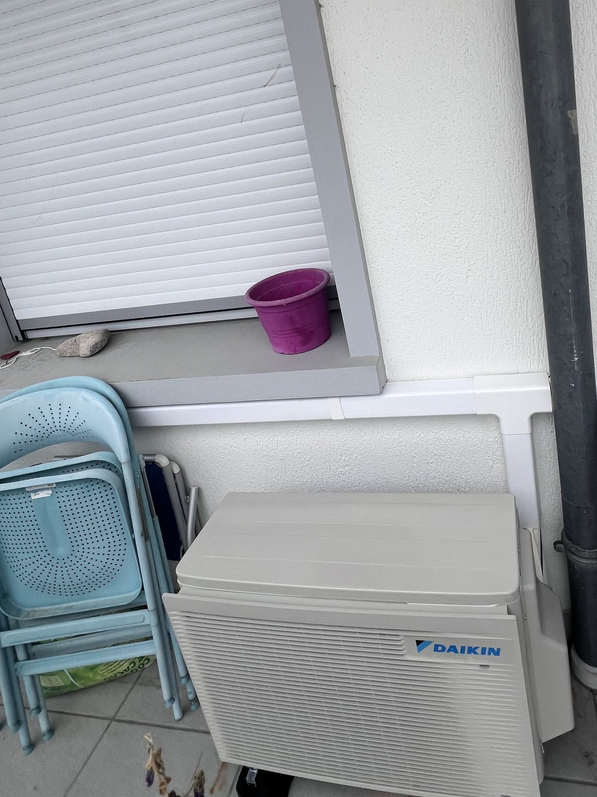 Groupe extérieur Daikin posé contre la façade sur un balcon d'appartement