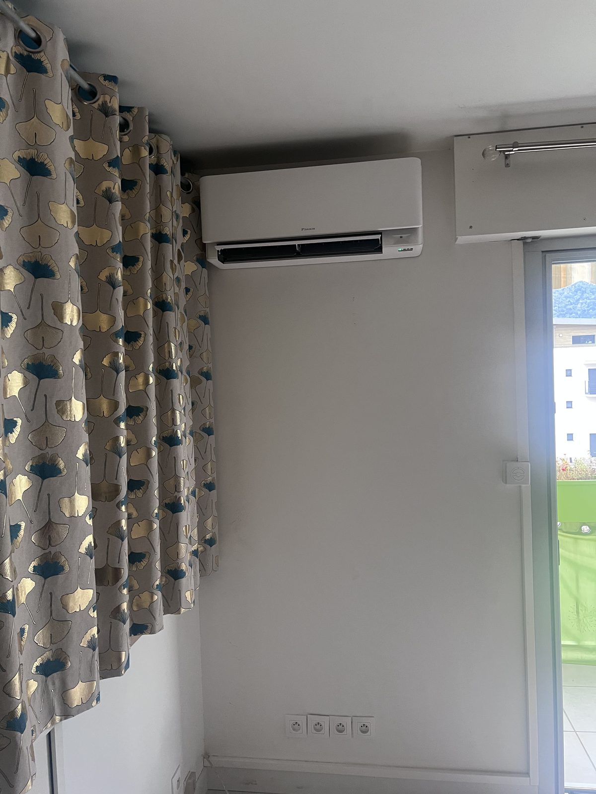 Unité murale Daikin posée en hauteur près de la baie vitrée